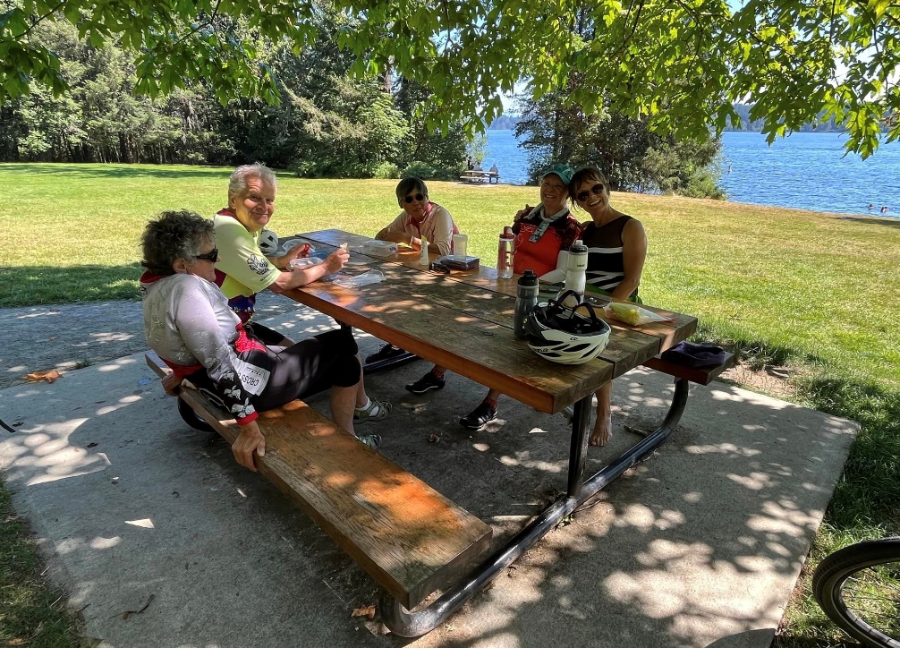 A group of people sitting on a picnic table

Description automatically generated with medium confidence