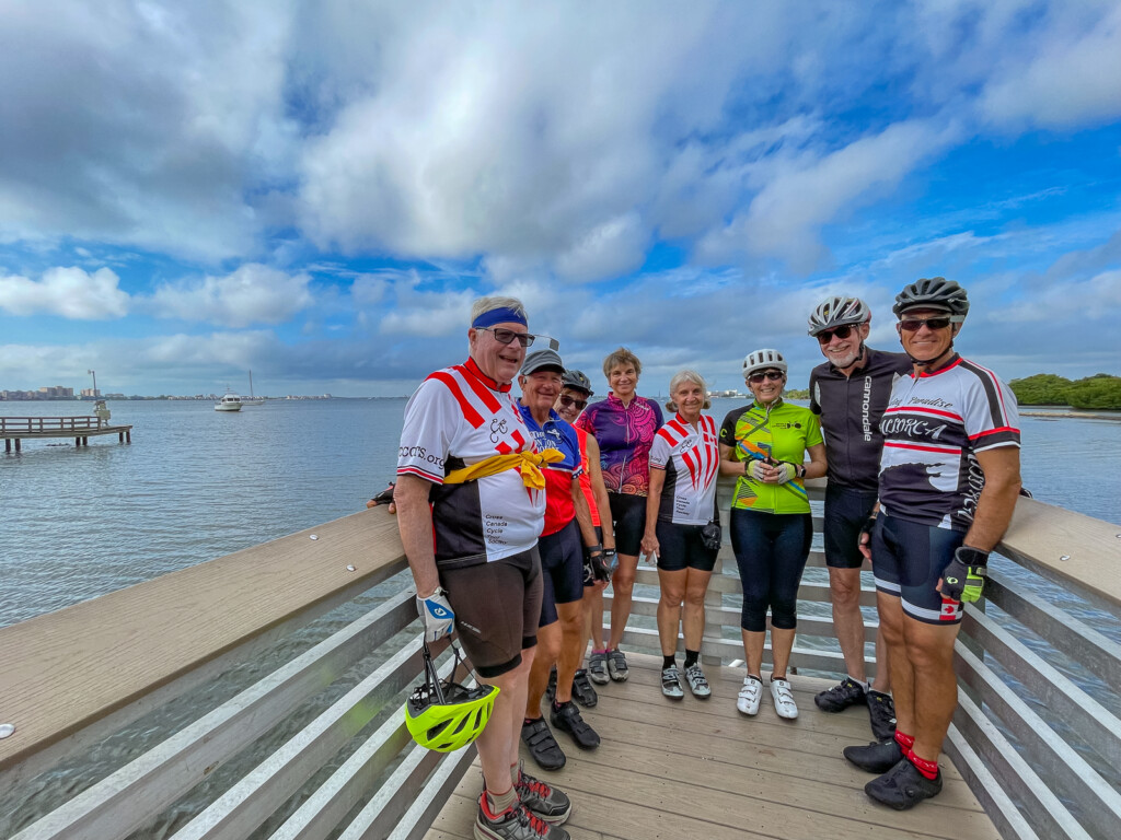 A group of people posing for a photo on a dock

Description automatically generated with medium confidence