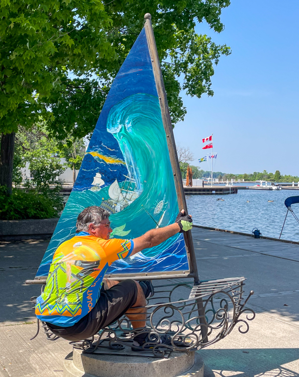 A person painting a sailboat

Description automatically generated