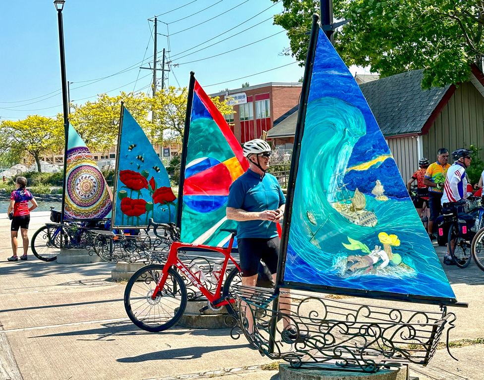 A person with a bicycle next to a group of sailboats

Description automatically generated with low confidence