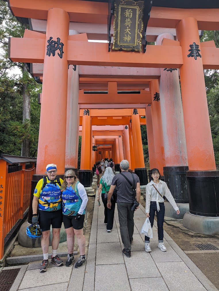 A group of people walking under an orange archway

Description automatically generated