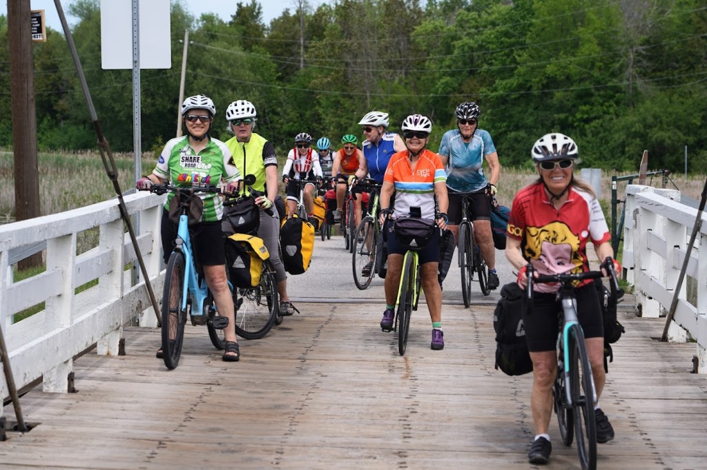A group of people riding bicycles on a bridge

Description automatically generated