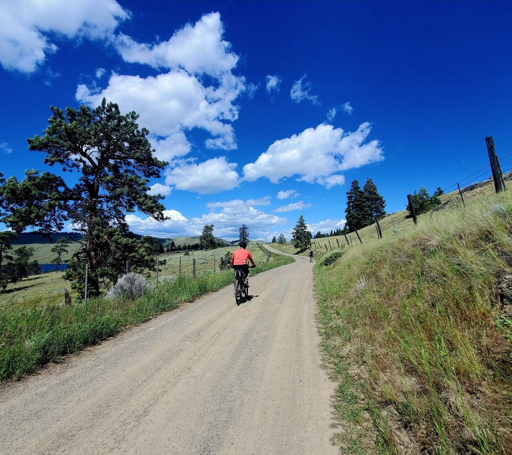 A person riding a bike on a dirt road

Description automatically generated