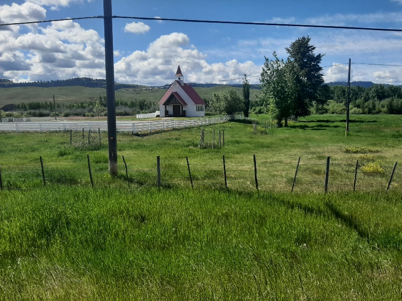 A white building in a field

Description automatically generated