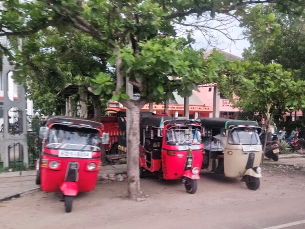 A group of tuk parked on a street

Description automatically generated