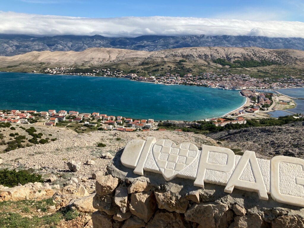 A stone sign on a rock with a body of water in the background

AI-generated content may be incorrect.