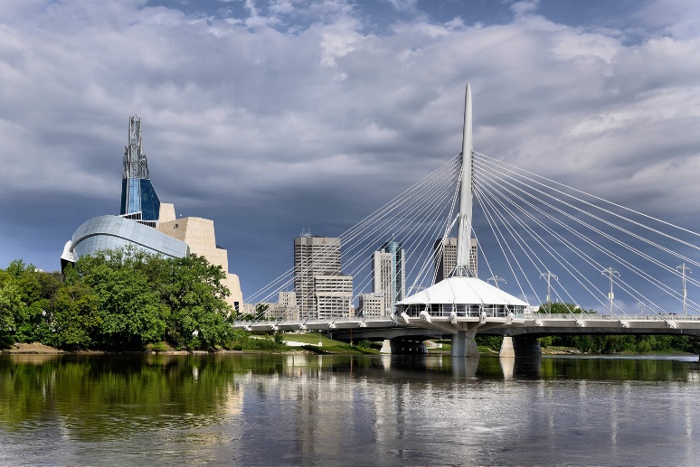 A bridge over a body of water with a city in the background

AI-generated content may be incorrect.