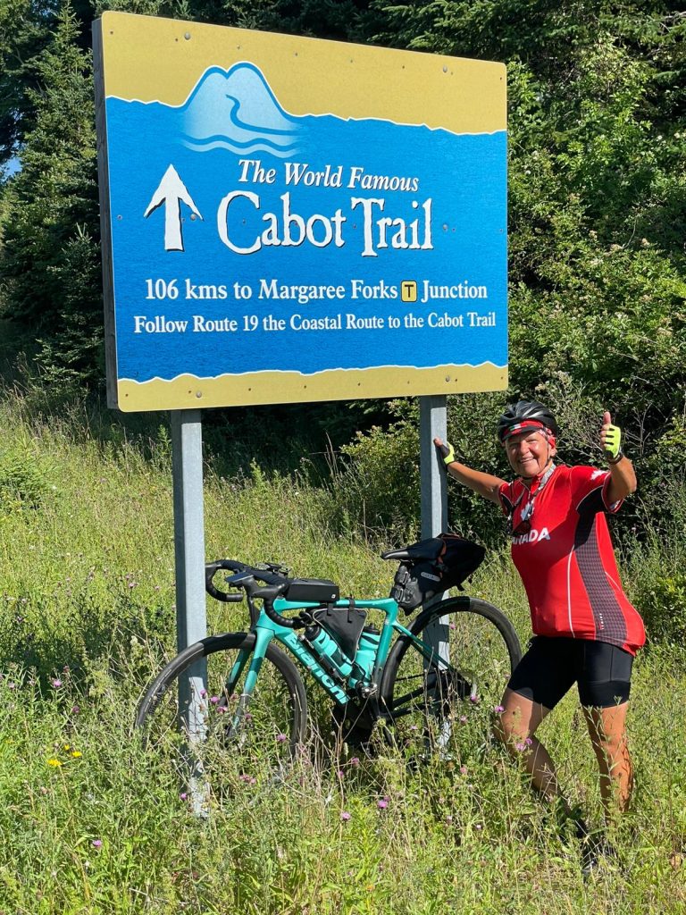 A person standing next to a sign

Description automatically generated