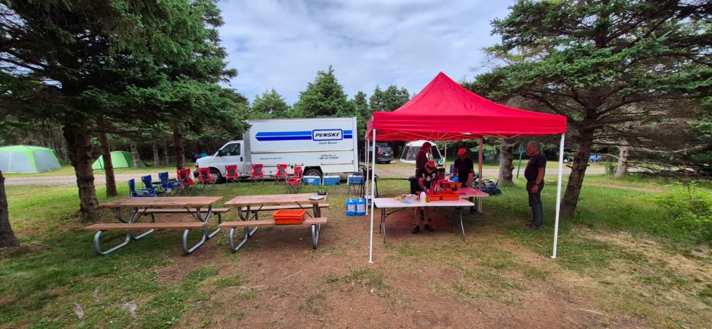 A tent and picnic tables in a park

Description automatically generated