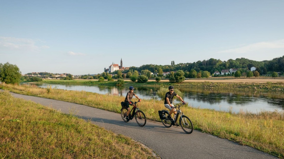 Two people riding bicycles along a path by a river

AI-generated content may be incorrect.